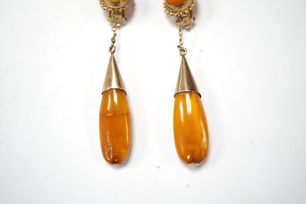 A pair of yellow metal and two stone amber set drop ear clips, 68mm, gross weight 8 grams. Condition - poor